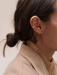 a close up of a person wearing a jacket and earring with a white background