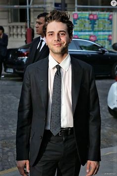 a man in a suit and tie walking down the street