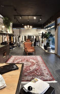 the inside of a clothing store with furniture and rugs