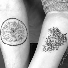 two people with tattoos on their arms holding each other's hands and one has a pine cone