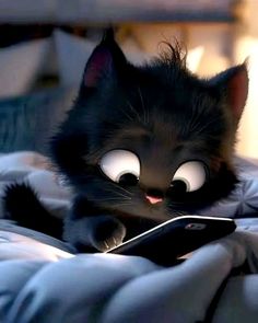 a black cat laying on top of a bed holding a cell phone in it's paws