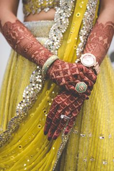 a close up of a person's hands with hennap and wrist jewelry