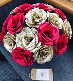 a bouquet of paper flowers sitting on top of a table next to a tag with music notes