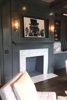 a living room filled with furniture and a fire place in front of a painting on the wall