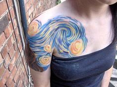 a woman with a tattoo on her chest has a swirly painting on her shoulder