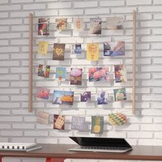 a laptop computer sitting on top of a wooden desk next to a white brick wall