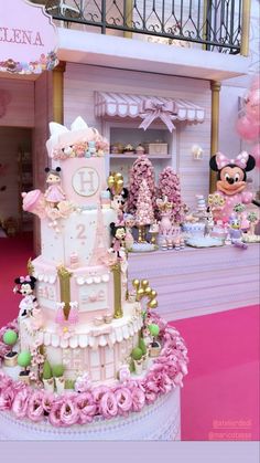 a pink and white cake sitting on top of a table