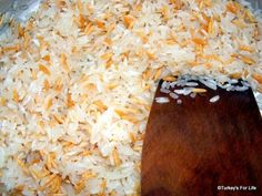 rice is being cooked in a pan with a wooden spoon