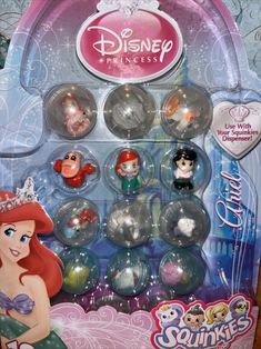 the little mermaid doll is in its box and has many different princesses on it