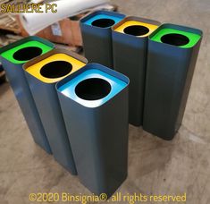 three black and yellow trash cans sitting on top of a floor next to each other