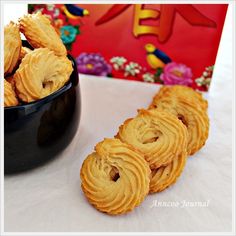 some cookies are in a black bowl next to a red box with chinese writing on it