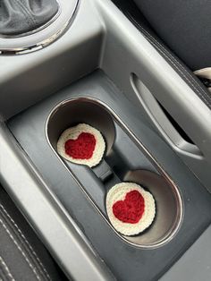 two crocheted heart shaped cupcakes in the center of a car seat