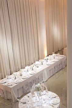 the tables are set up with white linens and place settings for formal dinner guests