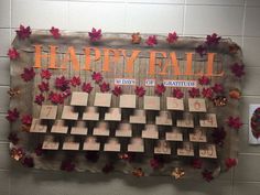 a happy fall sign hanging on the wall next to a calendar with leaves around it