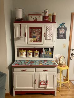 a kitchen with white cabinets and red shelves