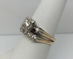 two gold rings with white diamonds on top of each other, sitting on a napkin ring