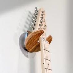 an electric guitar hanging on the wall with its neck and bridge made out of wood