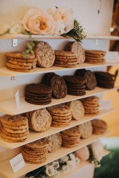 cookies and cookies are arranged on the shelves in front of each other, along with flowers