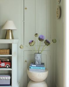 a vase filled with flowers sitting on top of a table next to a book shelf