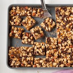 a pan filled with brownies and nuts on top of a table