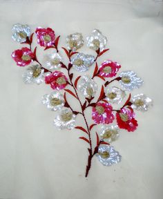 a close up of a flower on a white cloth with red and silver flowers in the center