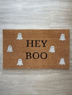 a door mat that says hey booo with ghost faces on the front and bottom