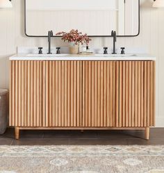 a bathroom vanity with two sinks and a large mirror above it, along with a rug on the floor