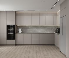 an empty kitchen with grey cabinets and white counter tops, along with a microwave on the wall