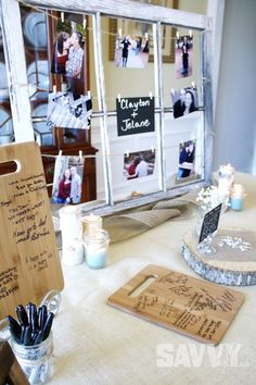 the table is set up for a wedding with pictures and writing on it's boards