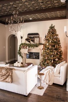 a living room decorated for christmas with a tree in the corner