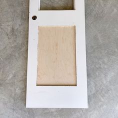 a white frame with a square cut out in the middle on a concrete floor area