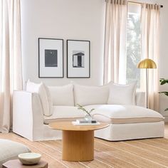 a living room filled with white furniture and decor on top of hard wood flooring