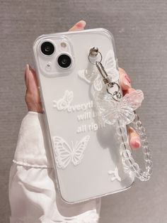 a person holding up a clear phone case with a keychain attached to it