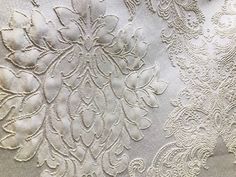 an image of white fabric with flowers and leaves on the back side, close up