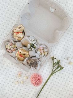 an open box filled with assorted candies and flowers