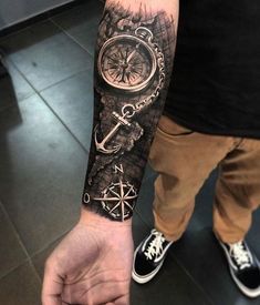 a man's arm with a compass and an anchor on it