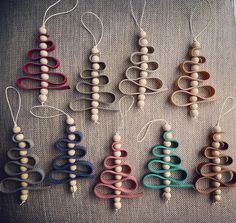 an assortment of wooden bead ornaments on a gray cloth covered table with white string