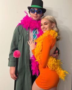 a man and woman dressed in costumes posing for the camera with their arms around each other