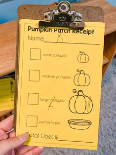 a person holding a clipboard with pumpkins on it and writing in the middle