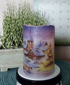 a frosted cake sitting on top of a table next to a potted plant