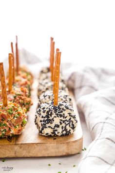 four donuts with sprinkles on them sitting on a cutting board, ready to be eaten