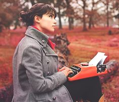 a woman standing in the middle of a field