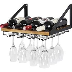 wine glasses and bottles are sitting on a rack