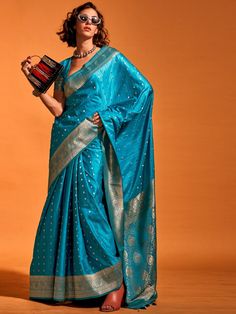 Wear this designer saree in a stunning sky-blue color, made from luxurious silk material, adorned with exquisite zari weaving work and attached tassels. This adorable sky-blue zari-weaving satin wedding wear saree is perfect for creating fashion statements at festivals, weddings, and events.
The set includes a blouse made from the same color silk material with zari weaving work. The saree measures 5.50 meters, allowing for versatile draping styles, and the blouse material is unstitched, providin Blue Silk Blouse Designs, Blue Sarees, Blue Silk Blouse, Satin Silk Saree, Handloom Weaving, Party Sarees, Teal Blue Color, Ready To Wear Saree, Satin Saree