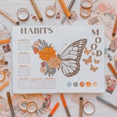 an open planner surrounded by various crafting supplies and scissors on top of a table