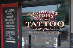 the front window of a tattoo shop with an advertisement on it's glass door