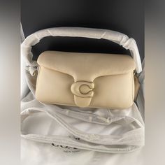 Brand New With Tags Never Used Coach Pillow Tabby 26 In Ivory (Larger Size). 100% Authentic. It Comes With A Short Strap, A Long Strap, And A Dust Bag. Purchased From 24s. Receipt Of Purchase Will Be Provided Upon Request. Msrp: $550 Nappa Leather And Smooth Leather Inside Zip Pocket Snap Closure, Fabric Lining Detachable Short Strap With 7 1/4" Drop Detachable Long Strap With 21 1/2" Drop For Shoulder Or Crossbody Wear 10 1/2" (L) X 5 3/4" (H) X 3" (W) Style No. C0772 Questions? Leave A Comment Below! Coach Pillow Tabby, Coach Pillows, Buy Bags, Ivory Color, Nappa Leather, Smooth Leather, Coach Bags, 4 H, Snap Closure