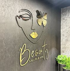 the sign for beauty salon and spa with butterflies on it's face, next to a potted plant