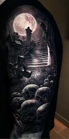 a man's back with a full sleeve tattoo on it and skulls in the foreground