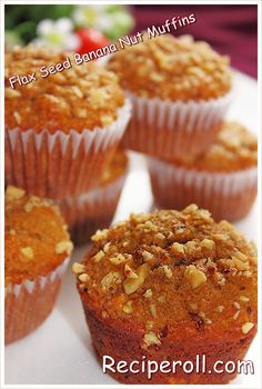 several muffins on a white surface with nuts